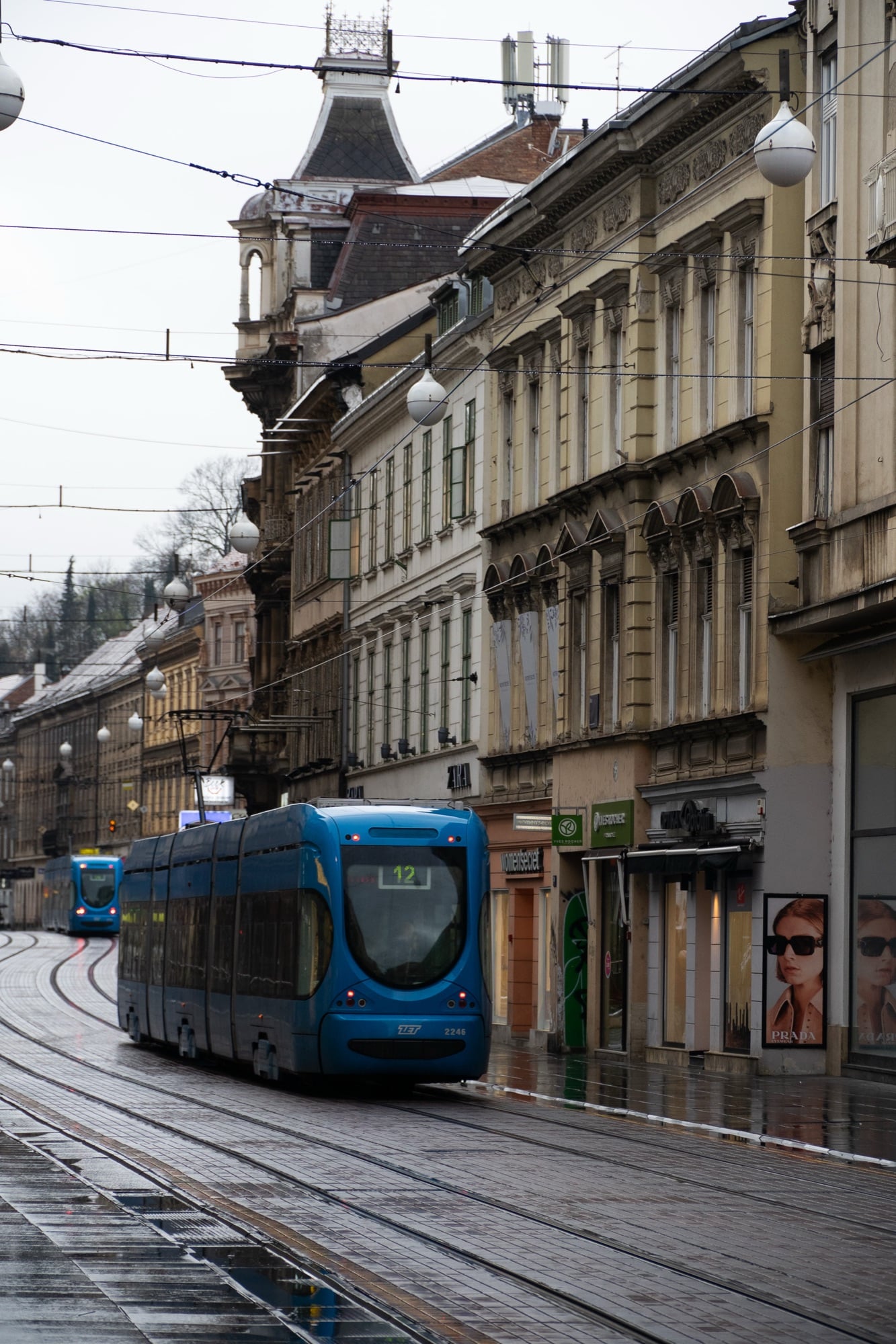 A blue tram running down a city street, Zagreb