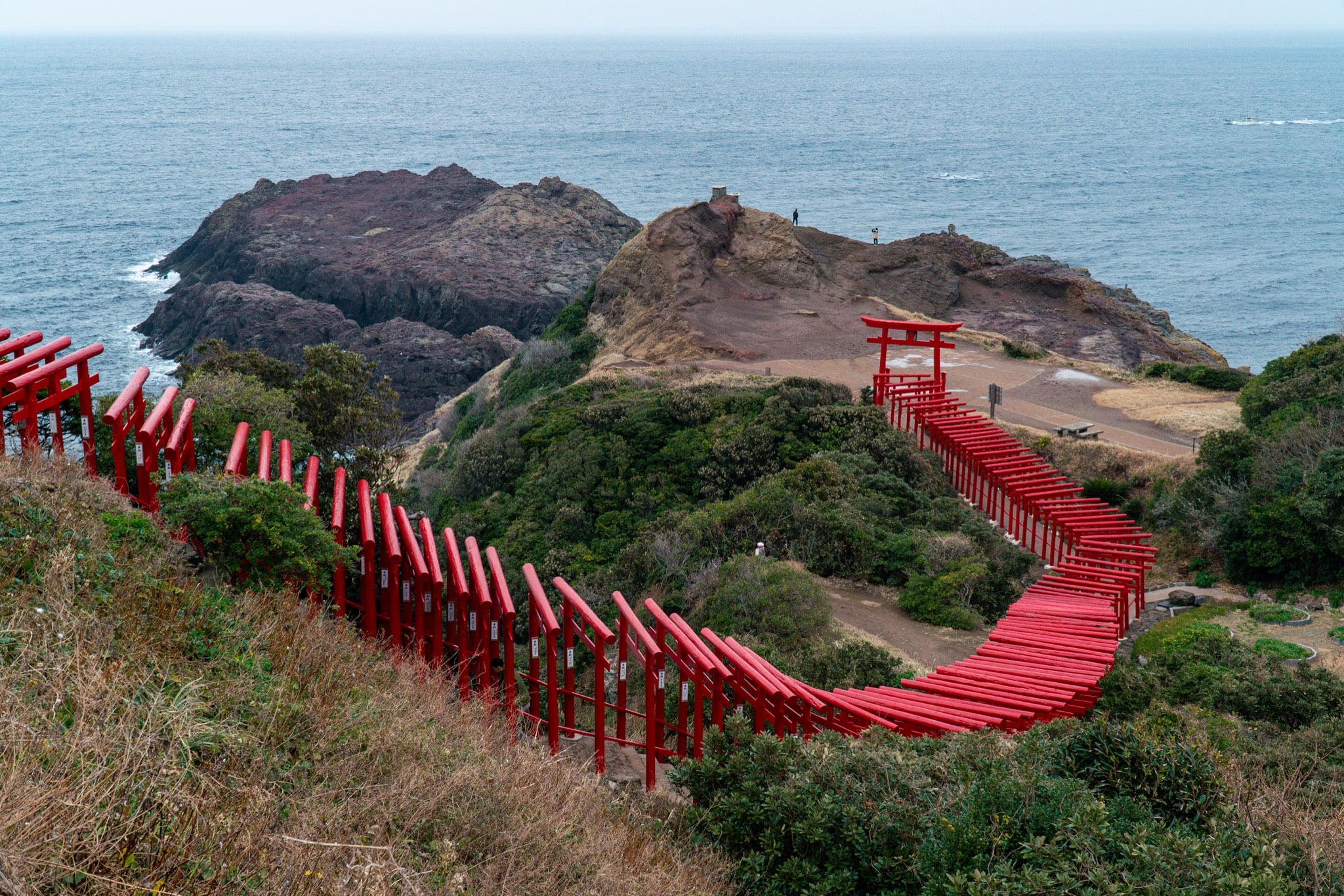 A run of red torii descending to the Sea of Japan at Motonosumi Inari